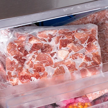An image of a frozen meat inside the fridge and in a plastic packaging