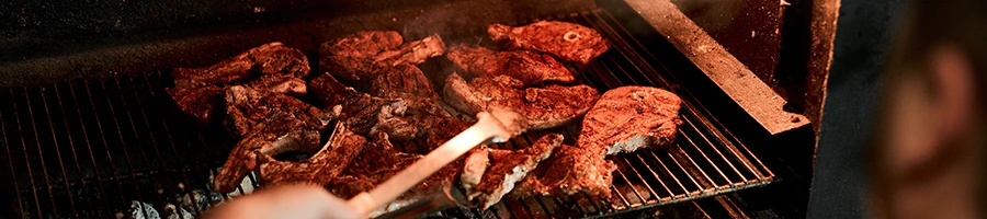 An image of a person grilling large quantity of meat