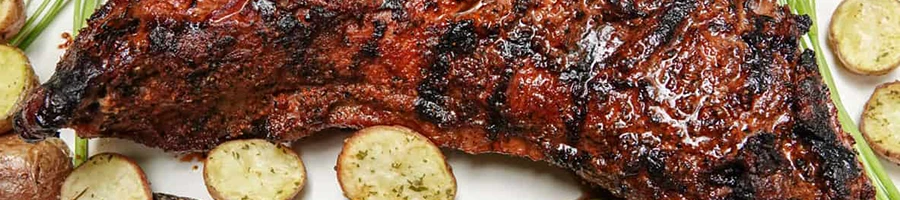 An image of roasted tri-tip steak with potatoes on the side