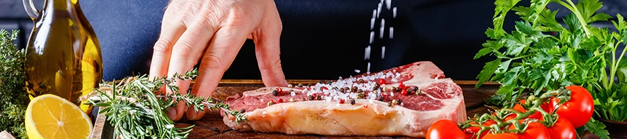 An image of a person pouring too much salt on meat for marinating