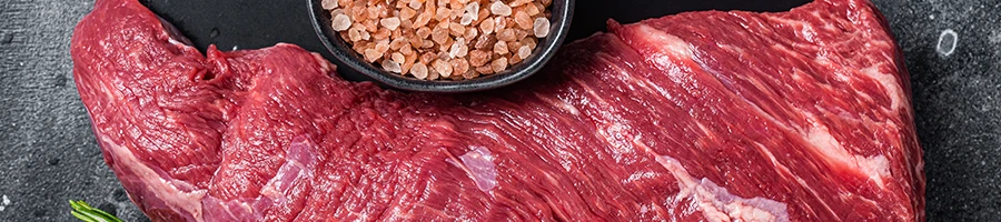 A top view image of raw tri-tip steak and salt