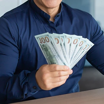 An image of a man holding dollar bills