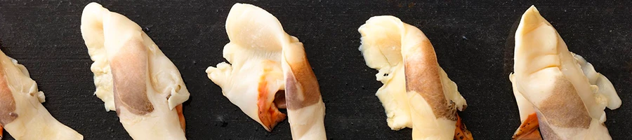 A top view image of conch meats on a black slate