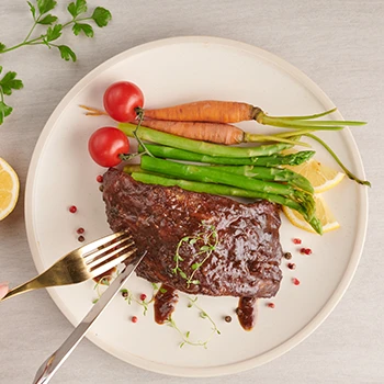 A top view image of bison meat dish with vegetables on the side