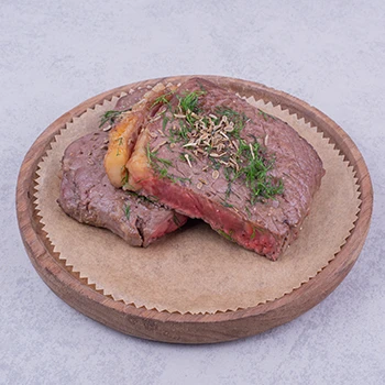 An image of bison and beef meat with herbs and spices on top
