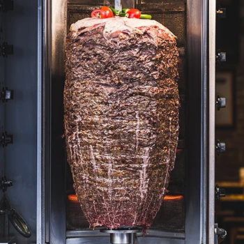 An image of gyro meat on a vertical rotisserie