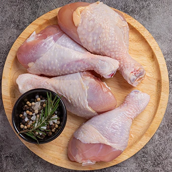 A top view of raw chicken legs on a wooden board