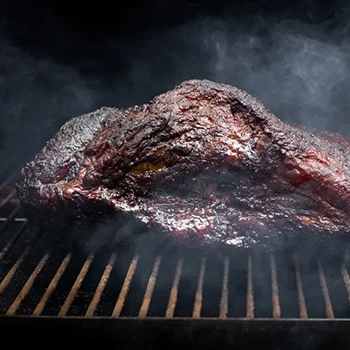A beef brisket being cooked inside a smoker