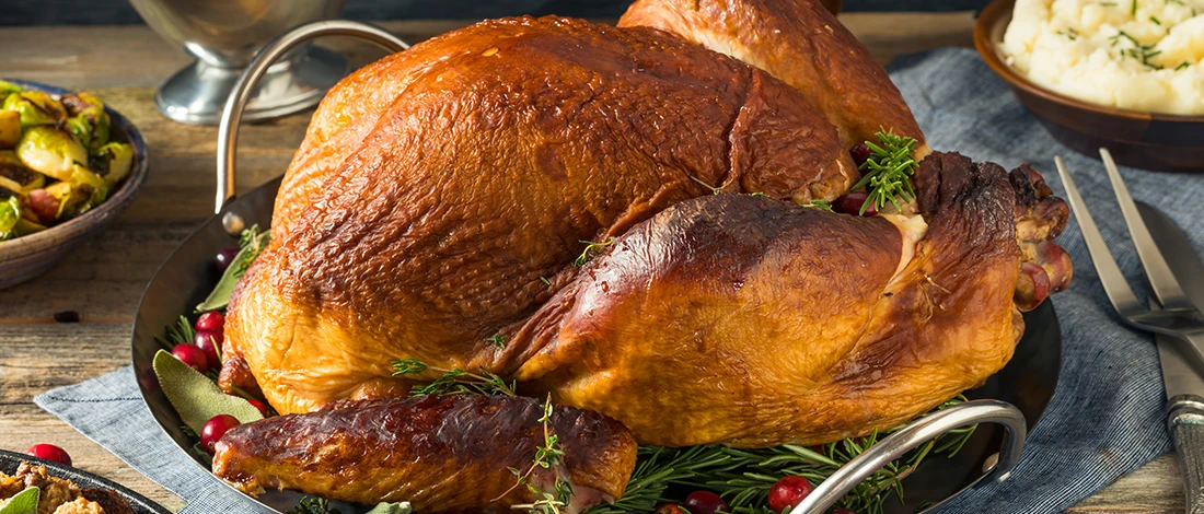 A close up shot of a roasted turkey on a black plate