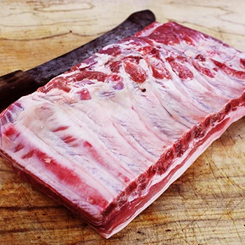 A fresh raw baby back ribs meat on a wooden board