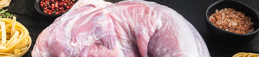 A close-up shot of raw rabbit and chicken meat with other ingredients on the side