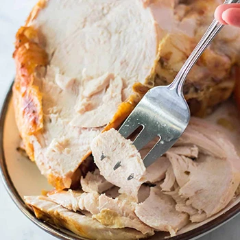 A piece of turkey meat on a fork that is rich in protein