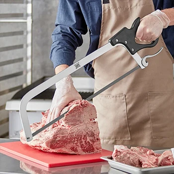 A butcher slicing a frozen meat with a butcher saw