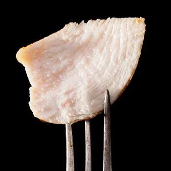 A close up shot of chicken rib meat on a fork