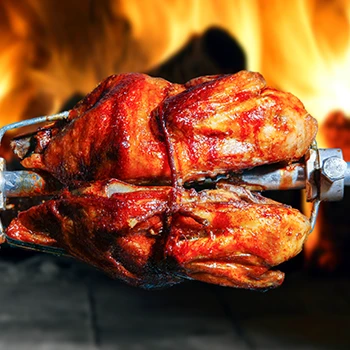 A close up shot of a chicken meat being grilled in a rotisserie
