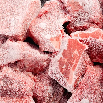 A close up shot of raw frozen meat with ice crystals