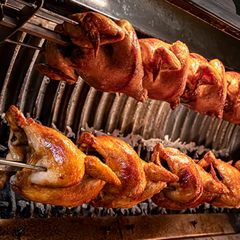 Chickens being cooked in a rotisserie grill