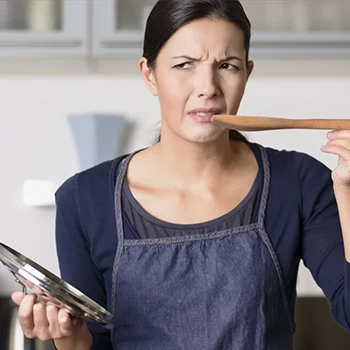 Unhappy woman in a kitchen who tasted disgusting food