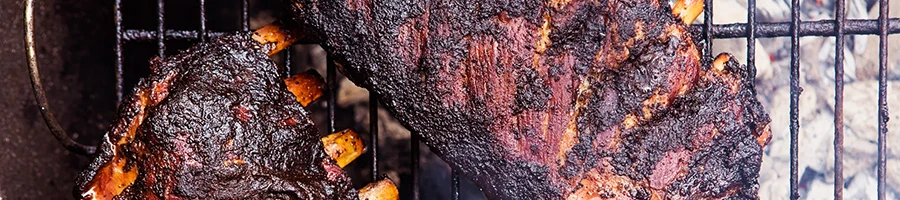 Meat being smoked using a charcoal grill