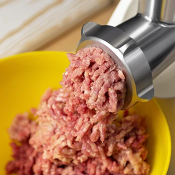 Close up shot of a meat grinder grinding beef meat