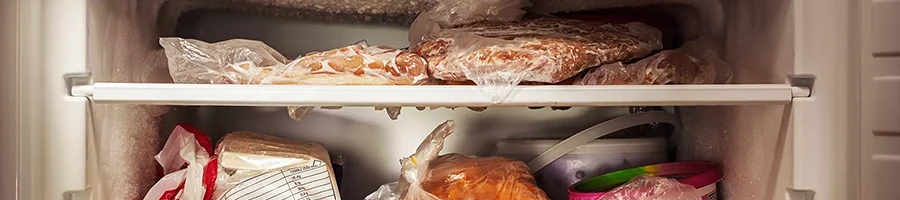 a fridge filled with frozen lunch meat and other meat products