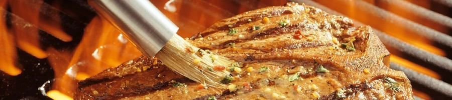 A close-up of a T-bone steak being grilled