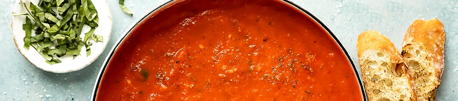 A close up shot of vodka sauce with bread on the side