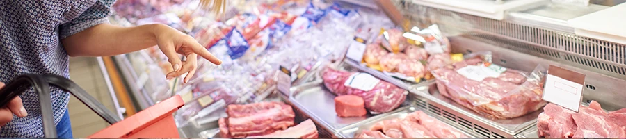 A woman buying fresh cuts of meat from a meat store