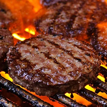 A close up shot of burger patties being grilled
