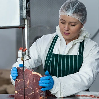 A woman cutting the meat that is bad for the environment