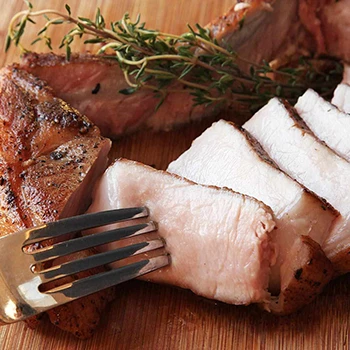 Undercooked pork and a fork on a wooden board