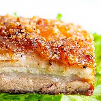 Crispy pork belly on top of a lettuce