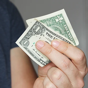 A close up shot of a person holding a dollar