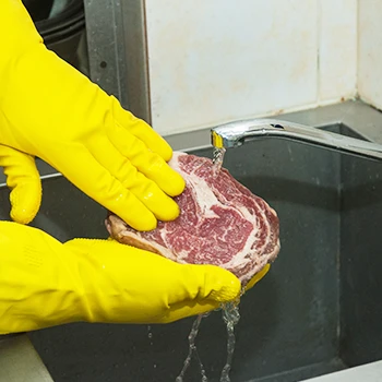 Washing the raw beef in the sink before cooking