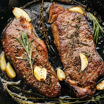 Cooking New York strip steak on a pan