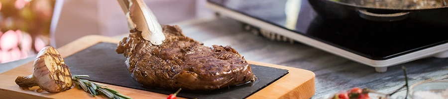 Putting a cooked tender cut of steak on top of a wooden board to rest