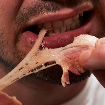 A close up shot of a person eating undercooked pork