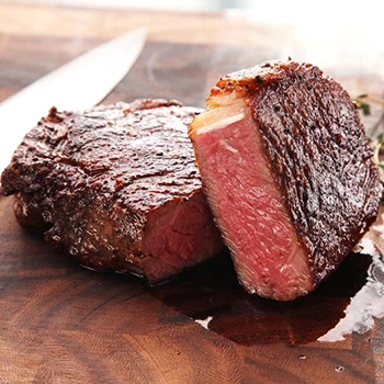 A sliced steak on a wooden board