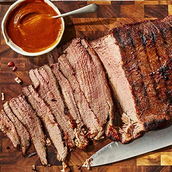 A top view of sliced brisket resting on top of a wooden board