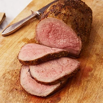 Baked eye of round steak on a wooden board