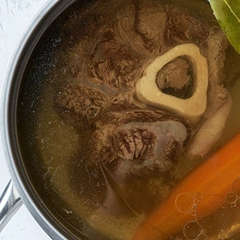 A top view of beef broth in a cooking pot