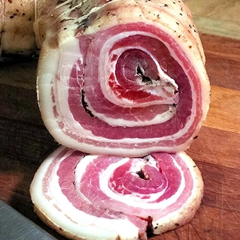 Sliced pancetta on a wooden board