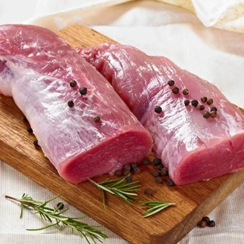 Raw pork tenderloin cuts on a wooden board