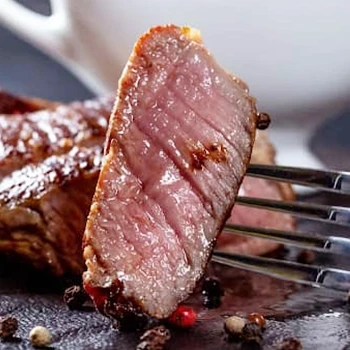 A close up shot of sliced sirloin steak on a fork