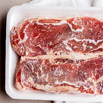 Frozen steaks on a white container