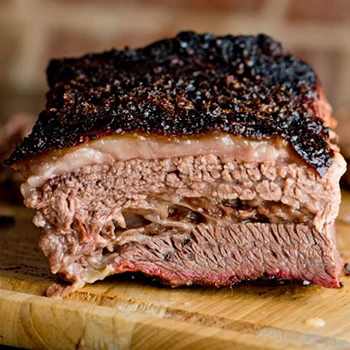 A close up shot of a brisket on a wooden board