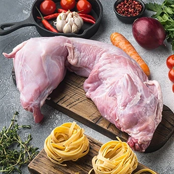 Raw rabbit meat on a wooden board with different ingredients