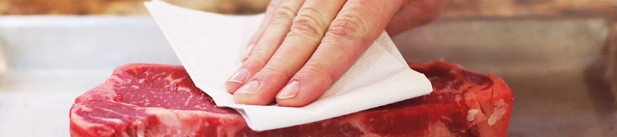 Patting prime rib with paper towels before refrigerating