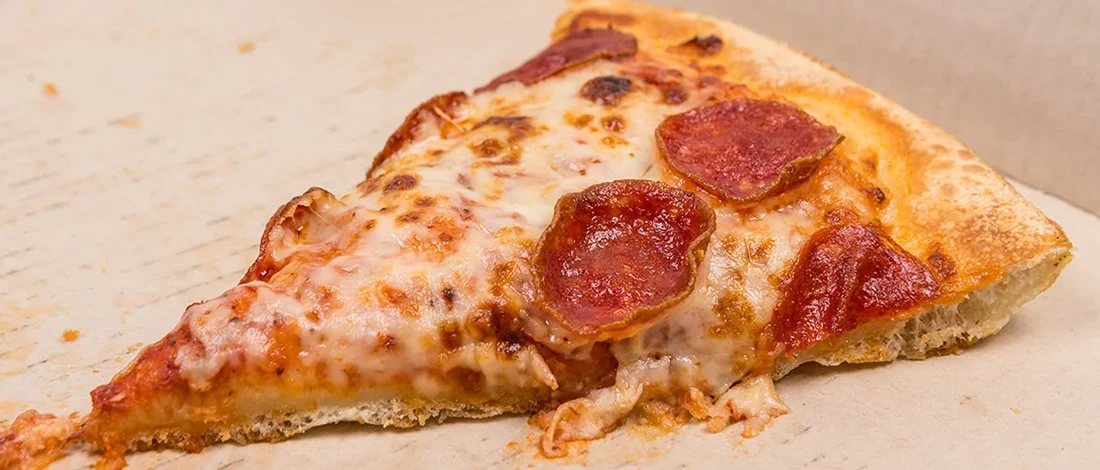 A close up shot of pizza slice stored in the fridge