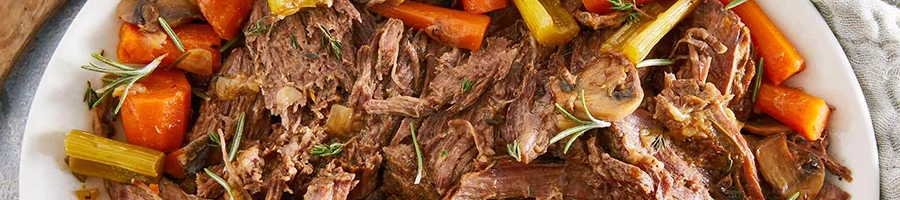 A close up shot of pot roast with vegetables